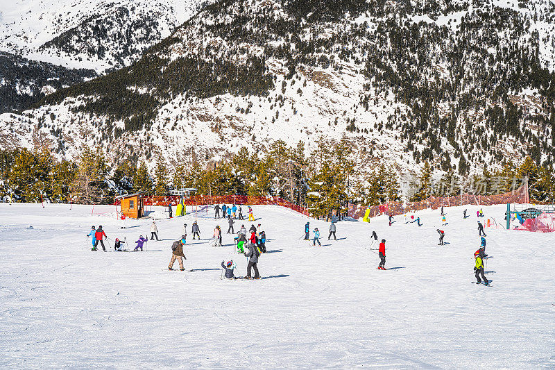 人们在安道尔的El Tarter绿色斜坡上玩耍，学习如何滑雪和滑雪板